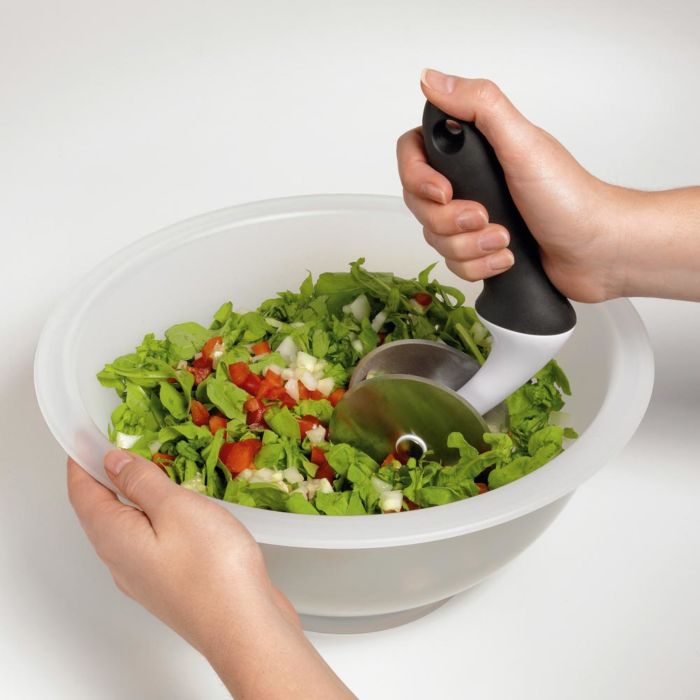 Woman chopping green salad in bowl
